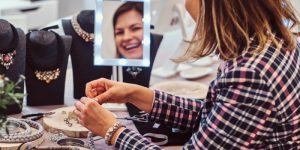 Woman trying jewellery in showroom mirror view
